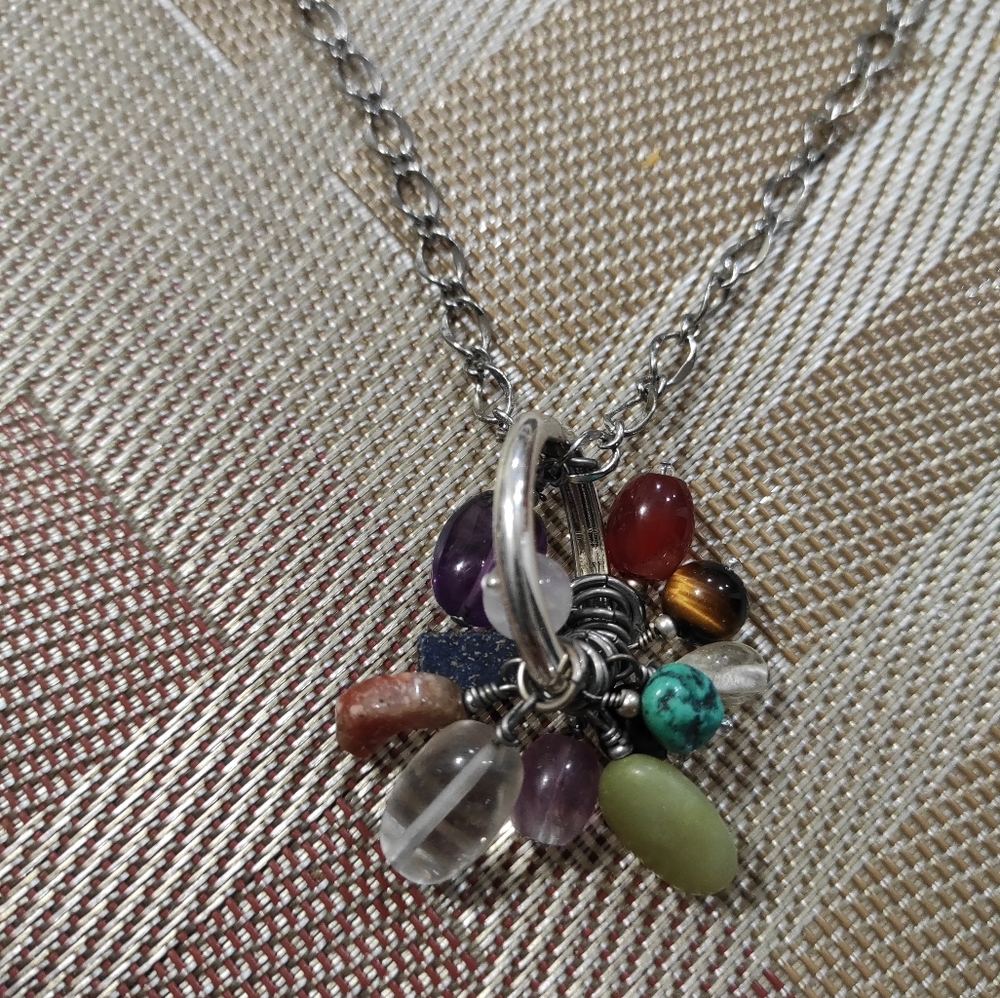 multicolor stones hanging off a silver chain